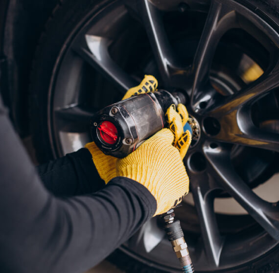 Technician performing inspection and repair on an alloy wheel to restore shape and finish at The Tire Studio