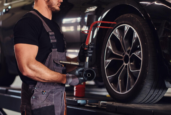 Technician repairing a scratched and bent alloy wheel at The Tire Studio
