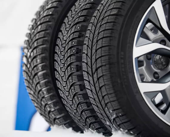 Close-up of a winter tire on snowy road highlighting traction, stability, and safe winter driving
